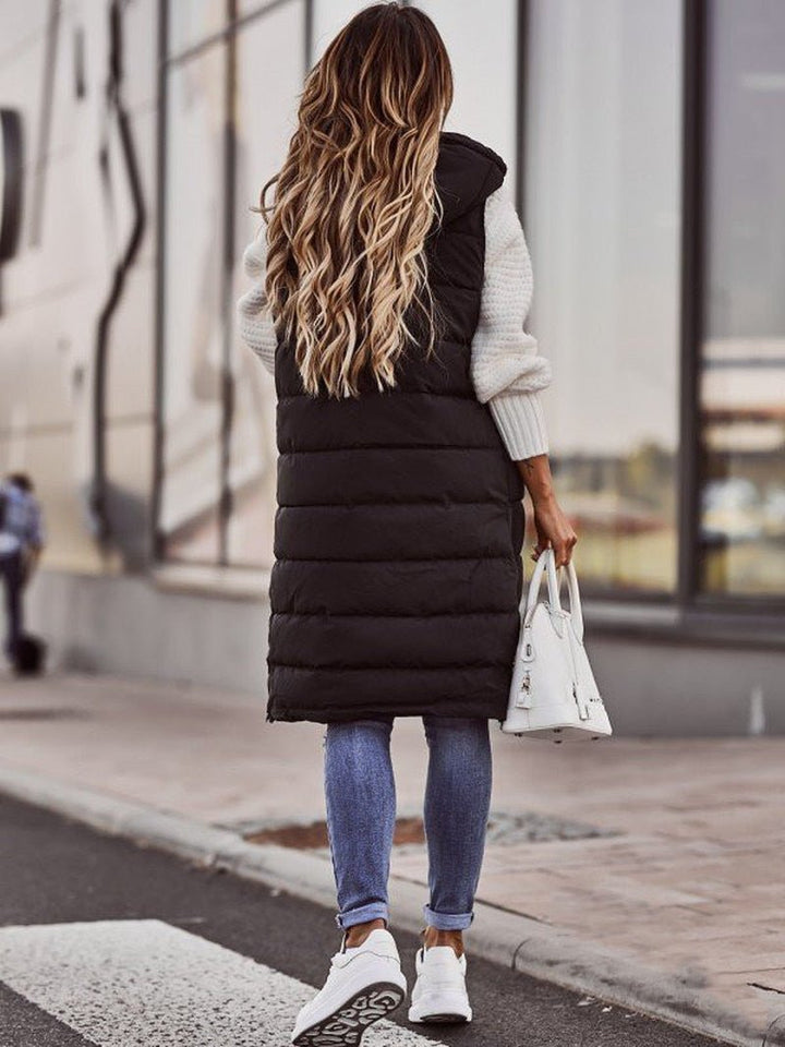 Close-up of a women's black quilted long vest, showcasing intricate stitching & warm, comfortable fabric.