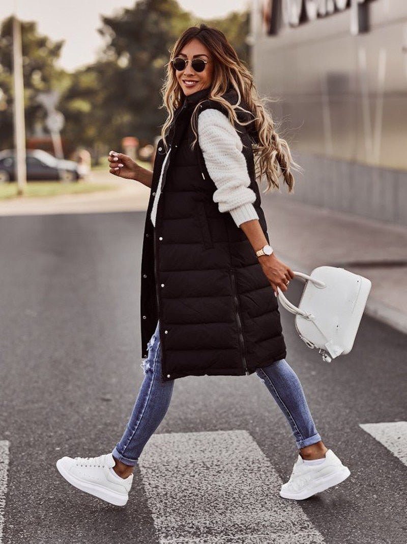 Woman wearing a chic black quilted long vest, ideal for stylish fall fashion & warm winter layering as a bodywarmer.