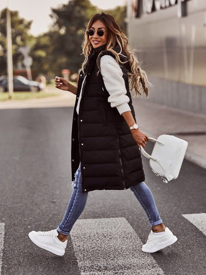 Woman wearing a chic black quilted long vest, ideal for stylish fall fashion & warm winter layering as a bodywarmer.