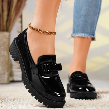 Elegant women's slip-on loafers, featuring a distinctive chunky sole and pretty bow, for a modern look.