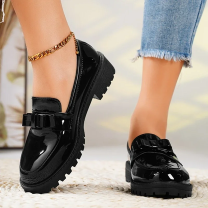 Women's stylish slip-on loafers with chunky sole. Comfortable footwear, featuring a decorative bow detail.