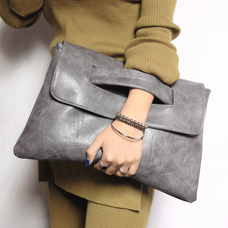 Close-up of the textured vegan leather and minimalist gold hardware on a chic women's shoulder bag.