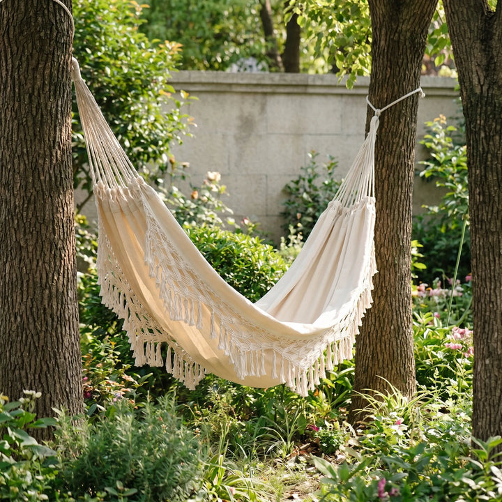 Tasseled hammock chair for ultimate patio relaxation; bohemian outdoor hanging seat for single person.