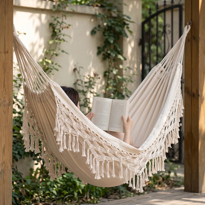 Bohemian tasseled hanging bed for garden relaxation; stylish outdoor furniture with fringe for patio.