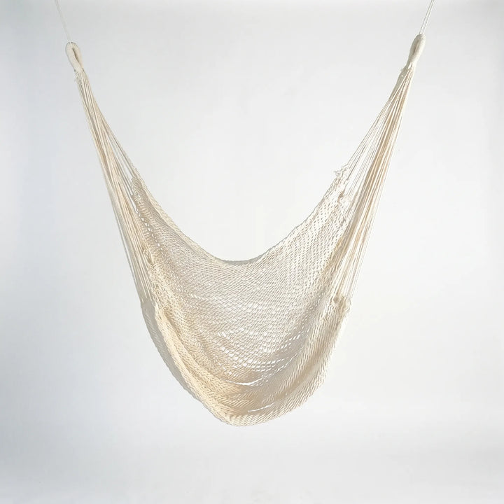 Stylish tasseled hammock chair, perfect bohemian patio furniture; a comfortable outdoor hanging seat.