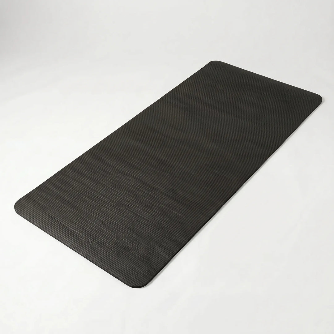 Person exercising on a thick, non-slip yoga mat. Provides joint support for comfortable home gym Pilates workouts.