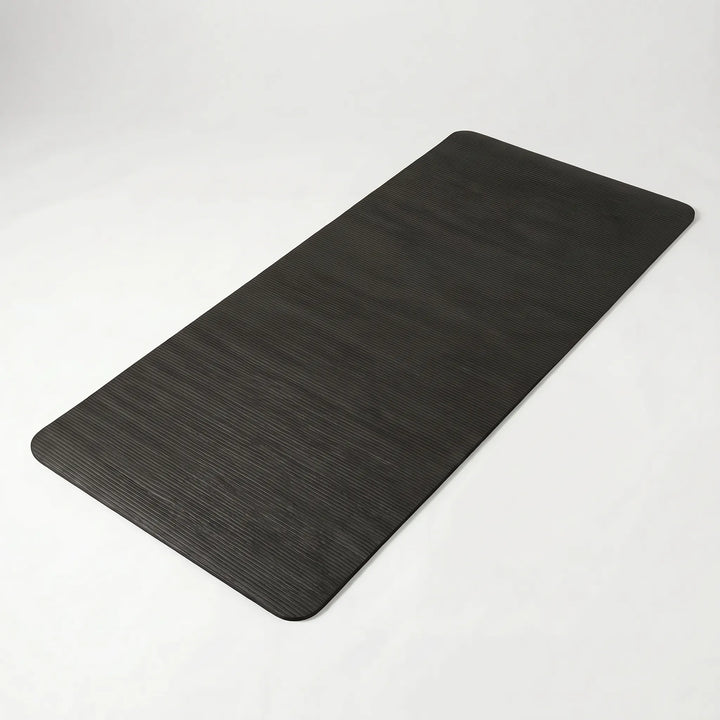 Person exercising on a thick, non-slip yoga mat. Provides joint support for comfortable home gym Pilates workouts.
