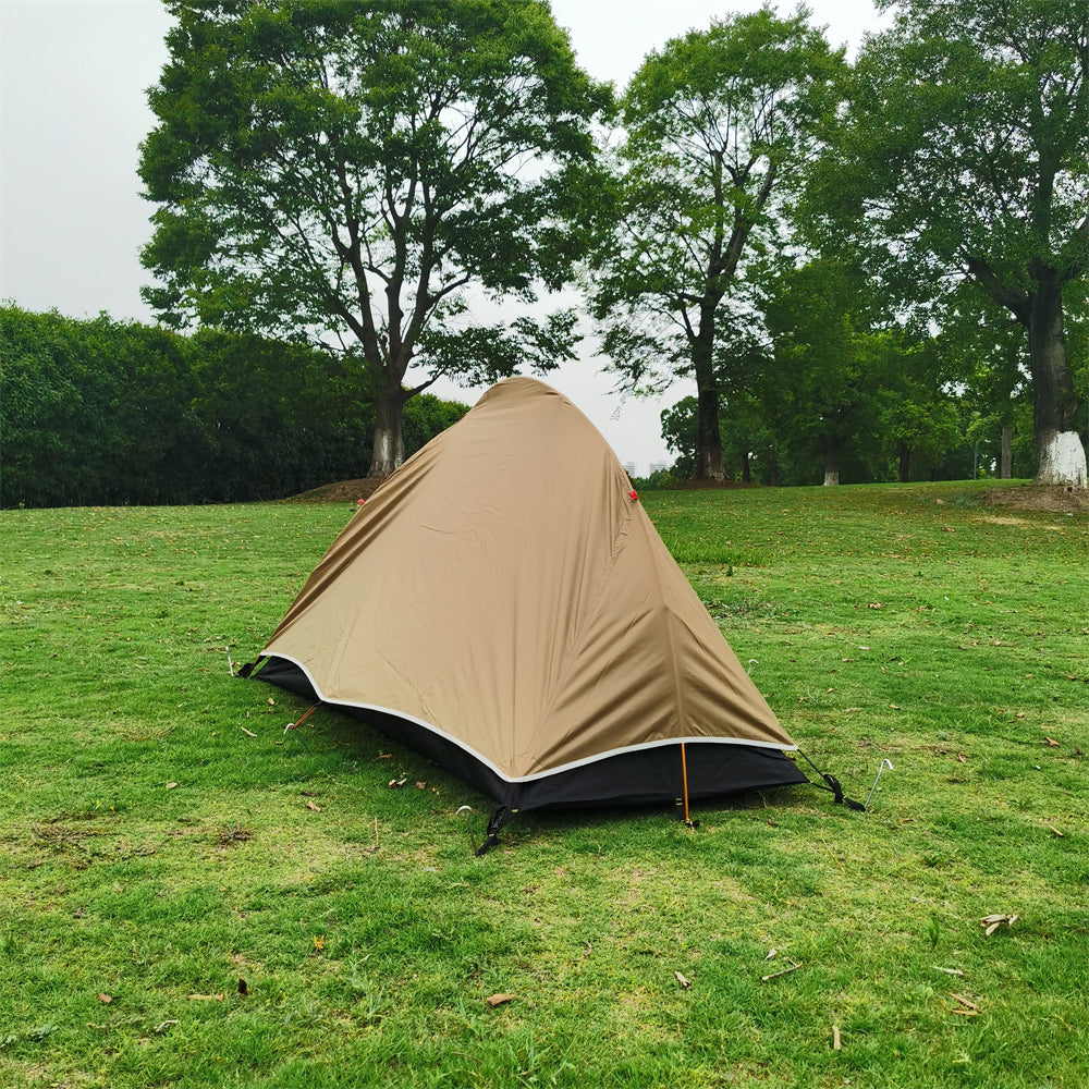 Bivy tent setup in a forest clearing, showing its small footprint for solo outdoor shelter