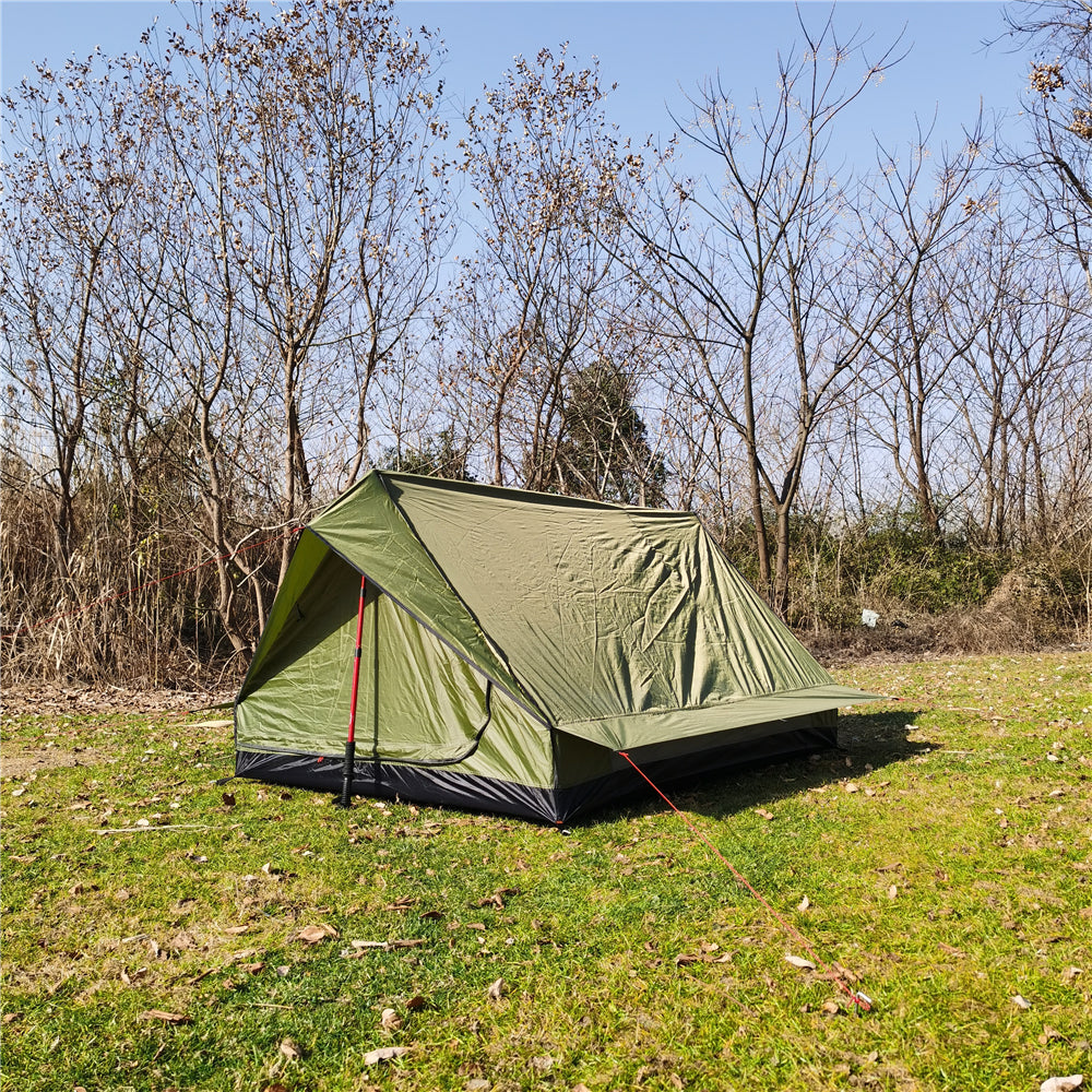 Camouflage A-frame solo tent blending into a woodland environment.