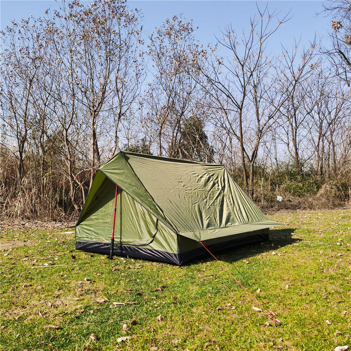Camouflage A-frame solo tent blending into a woodland environment.