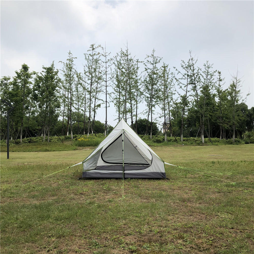 Solo A-frame camping tent pitched on a mountain ridge at sunset.
