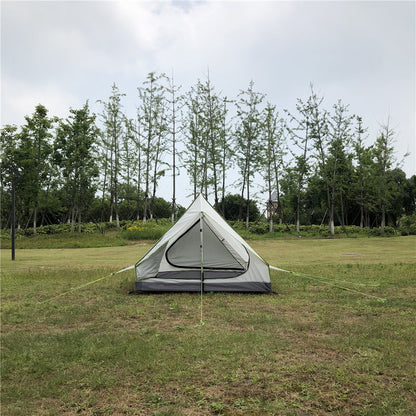 Solo A-frame camping tent pitched on a mountain ridge at sunset.