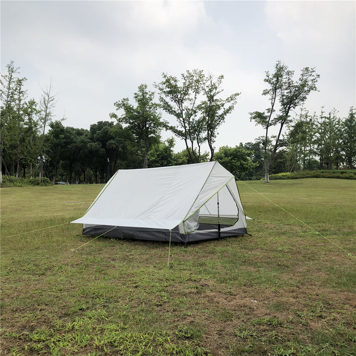 Duo ultralight trekking tent with two people inside, illuminated.