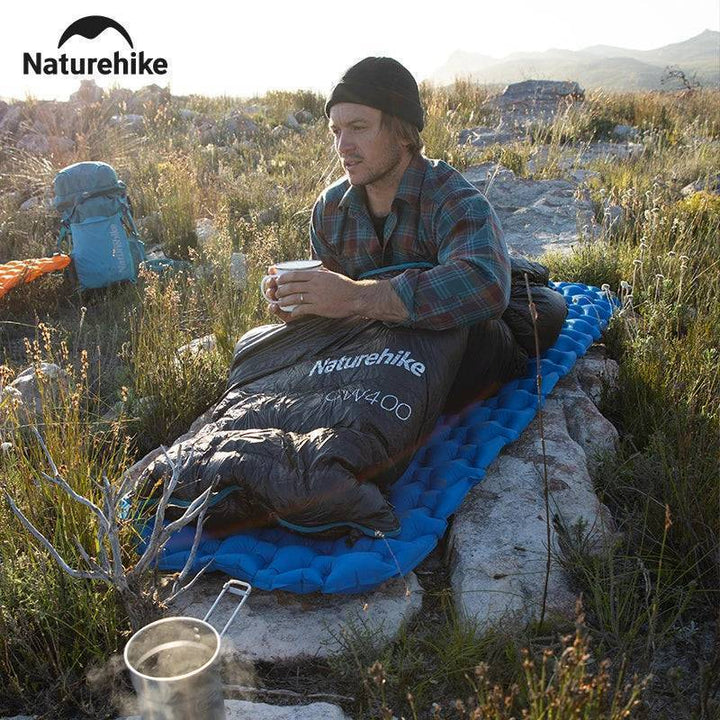 Ultralight duck down sleeping bag rolled up, demonstrating portable design for hiking storage