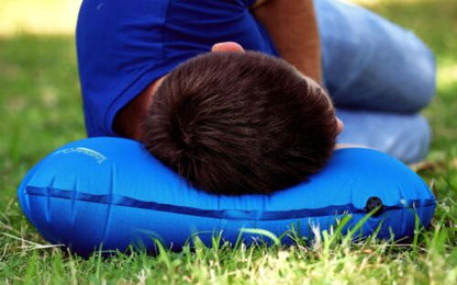 Inflatable camping pillow, dark blue, deflated and folded for space-saving packing