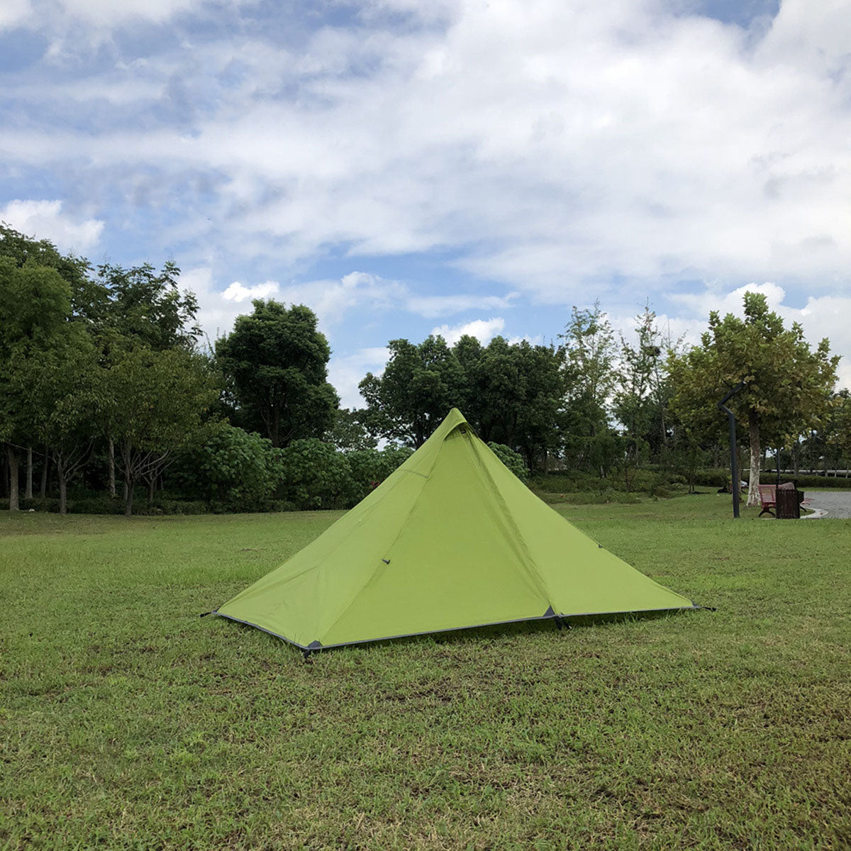 Pyramid trekking pole tent with a backpack next to it, indicating its backpacking utility.