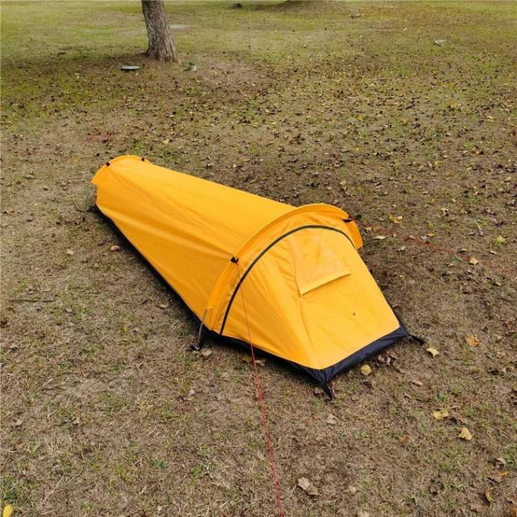 An erected ultralight single person tent at sunrise, showcasing its low profile and stability for outdoor adventure