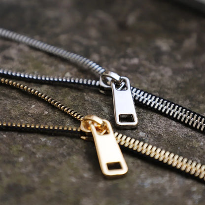 Close-up of a unique women's zipper necklace, showcasing intricate gold and silver design details.