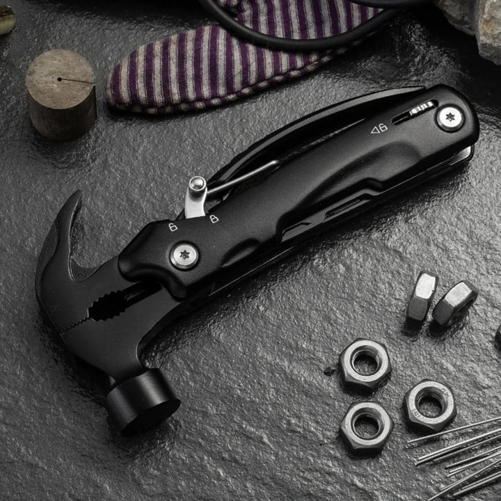Hand holding a compact 13-in-1 hammer multitool for fieldwork and camping