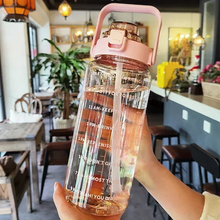 Unisex 2L portable water bottle with straw & time markers for daily hydration.