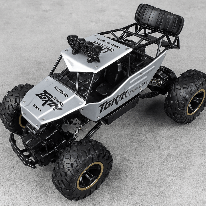 Unisex All-Terrain RC Monster Truck tackling rough terrain with big wheels.