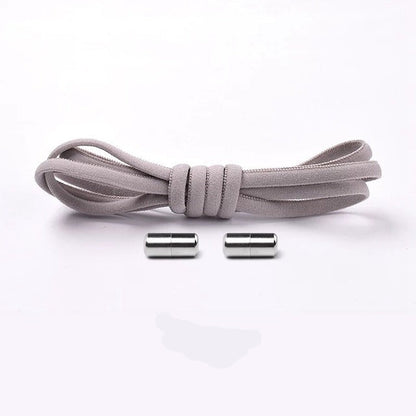Child easily slipping on shoes with blue elastic no-tie shoelaces, convenience