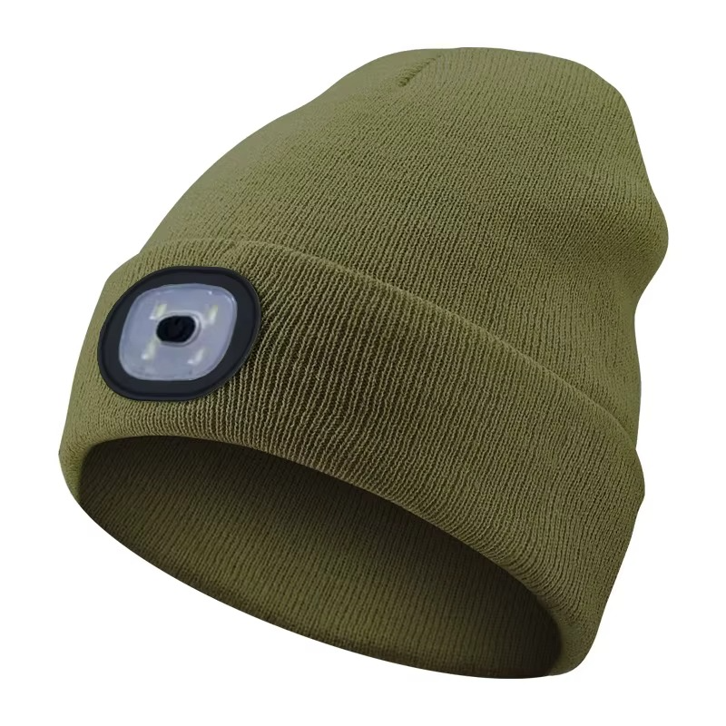 Person setting up a tent at night, illuminated by the hands-free light of an LED beanie hat.