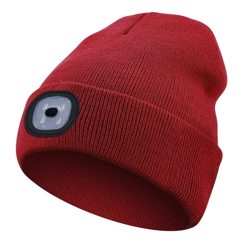 Runner on a trail at dusk, clearly visible due to the bright LED light on their beanie.