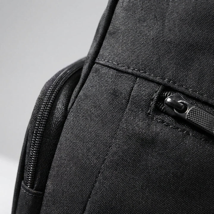 Versatile black unisex roll-top backpack, waterproof, for daily commuting, travel, & secure laptop carry.
