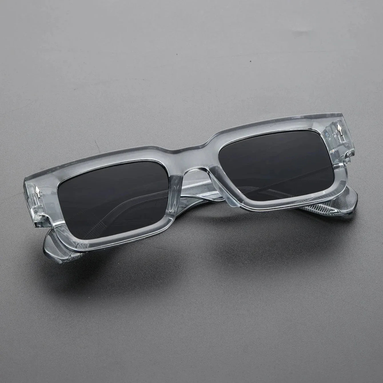 Bold rectangular UV protection shades in translucent black. Unisex fashion eyewear, a lightweight statement accessory.