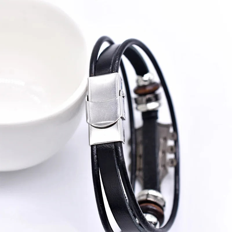 Adjustable dark unisex leather bracelet with a guitar charm, a versatile music lover's accessory for men & women.