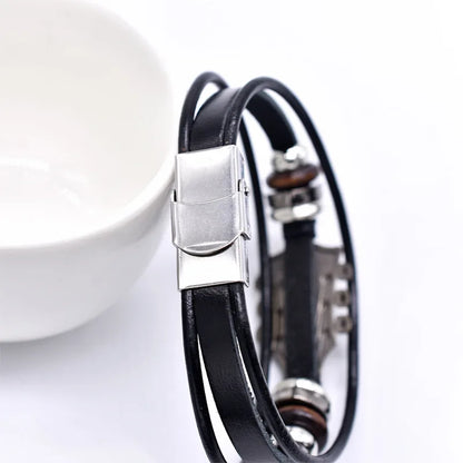 Adjustable dark unisex leather bracelet with a guitar charm, a versatile music lover's accessory for men & women.