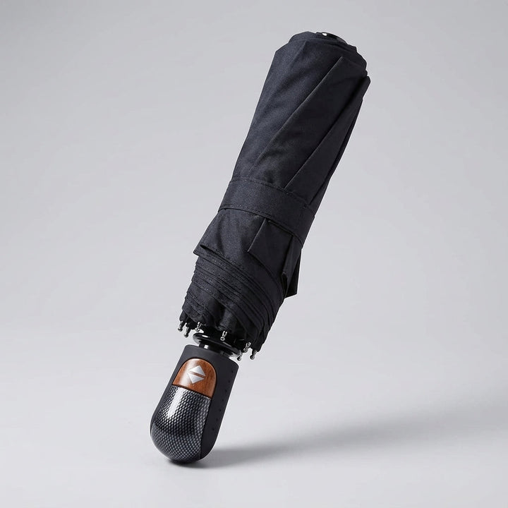 Windproof & waterproof BrollyMax auto-open travel umbrella in use, protecting from rain. Essential rain gear.