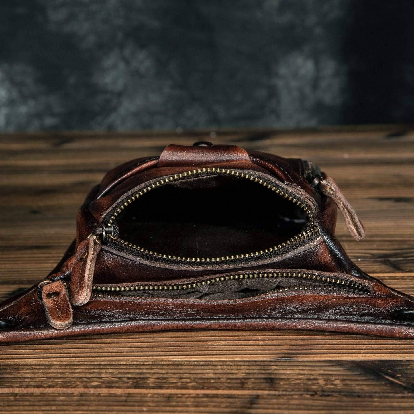 Close-up of genuine cowhide texture on classic unisex leather shoulder bag/waist pack