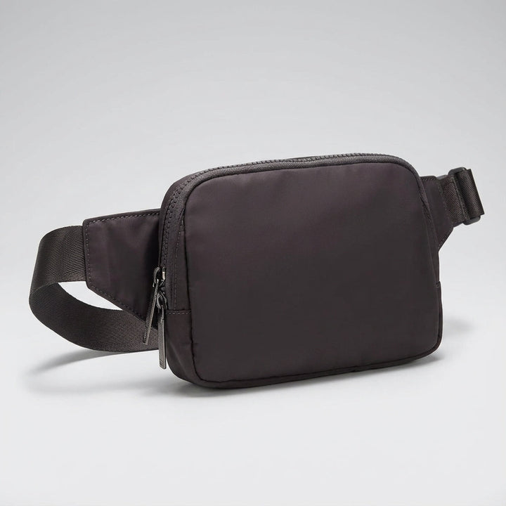 Versatile black nylon fanny pack, water-resistant and compact. Ideal crossbody bag for daily essentials.
