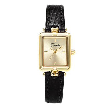 Unisex elegant watch. Black faux leather strap & round gold face on a clean background. Fashion accessory.