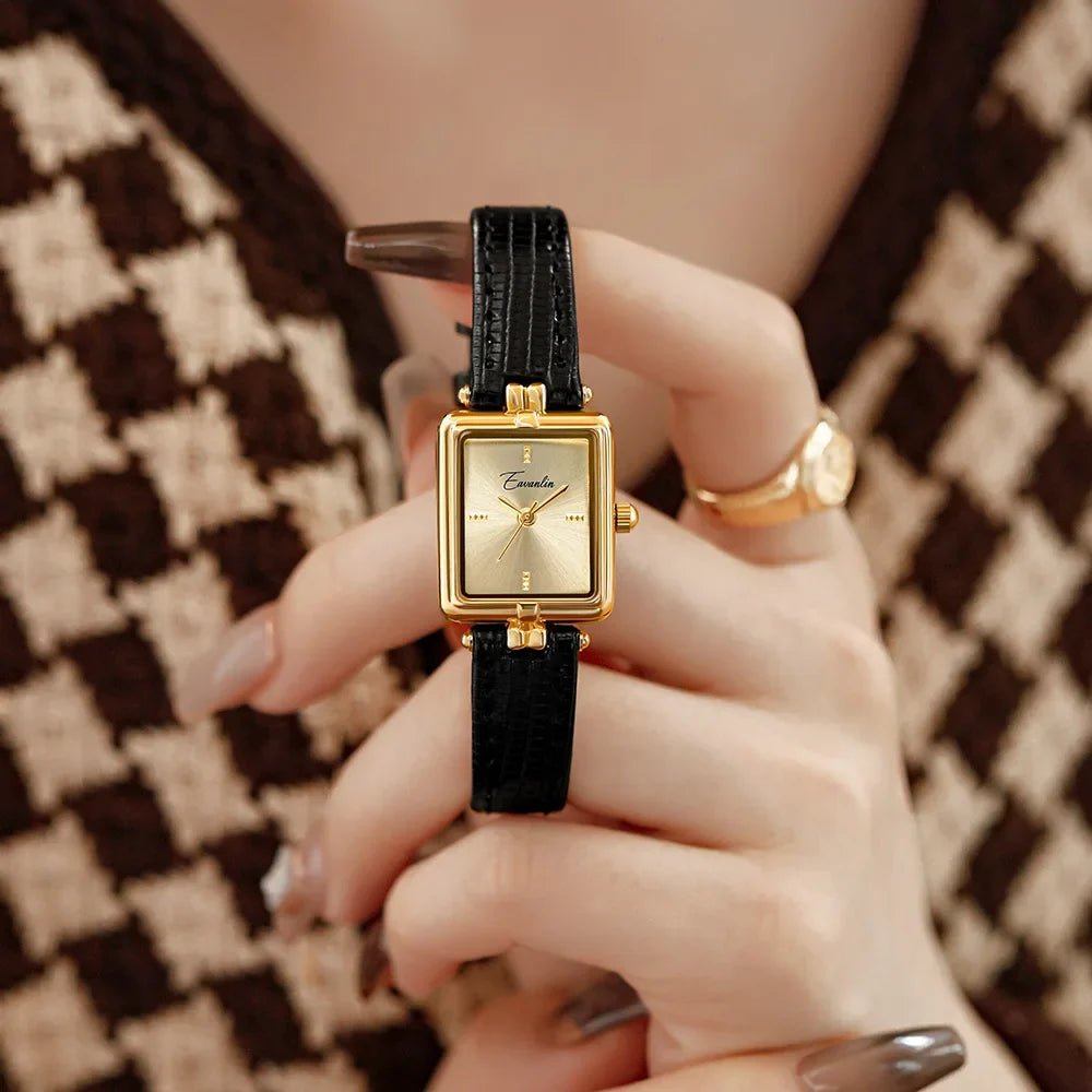 Elegant unisex watch on a wrist, featuring a black faux leather strap & gold face. Perfect formal accessory.