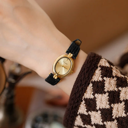 Durable black faux leather strap of a unisex watch, paired with an elegant gold face. Comfortable accessory.