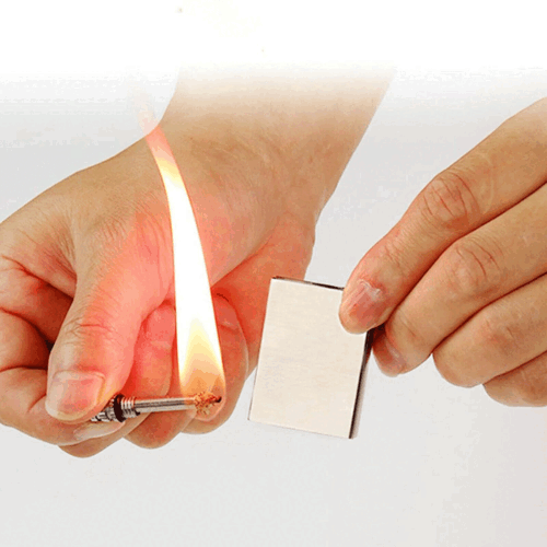 Hand holding waterproof flint match lighter, highlighting its portability and ease of use