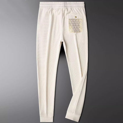 Comfortable unisex everyday pants, ribbed texture, elastic waist, & subtle gold hardware for stylish lounge.