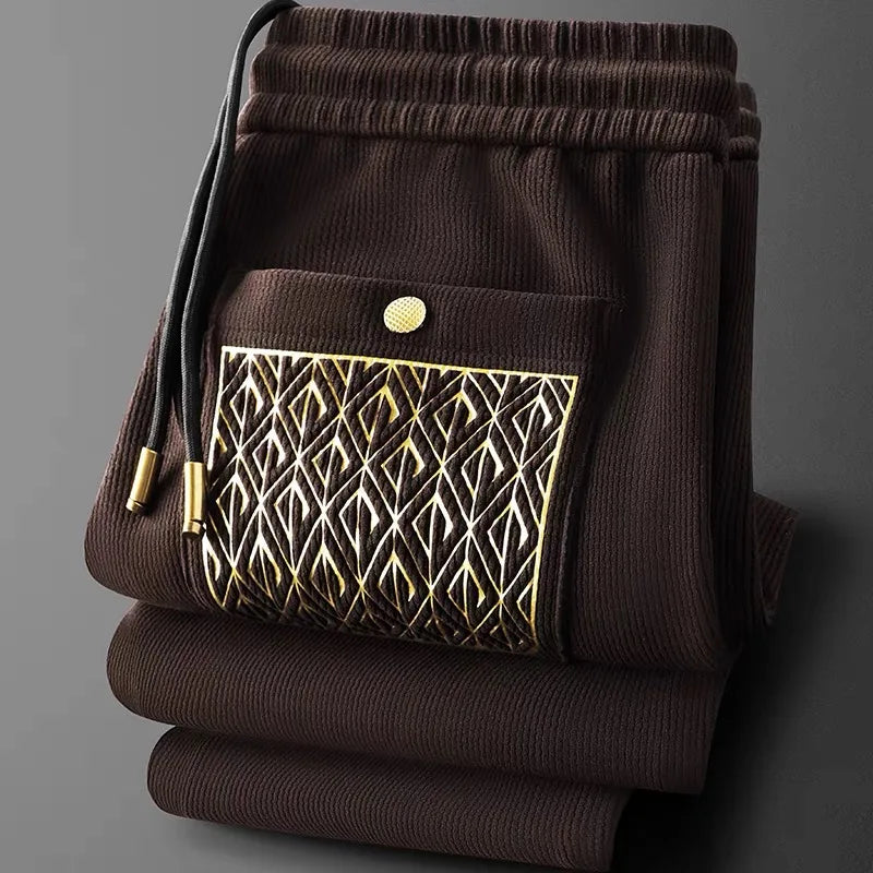 Ribbed knit unisex comfort pants in black, offering a relaxed fit & subtle luxury with gold hardware.