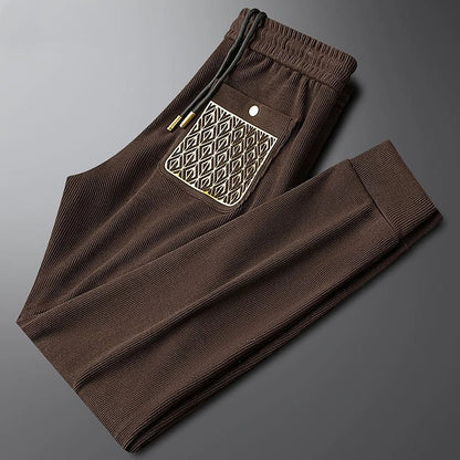 Unisex black comfort trousers, versatile for all, featuring ribbed texture & luxurious gold accents.