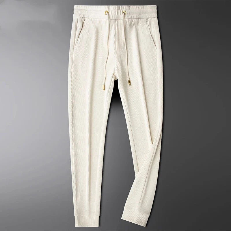 Close-up of luxe gold details on drawstring & pocket zipper of unisex everyday comfort pants.