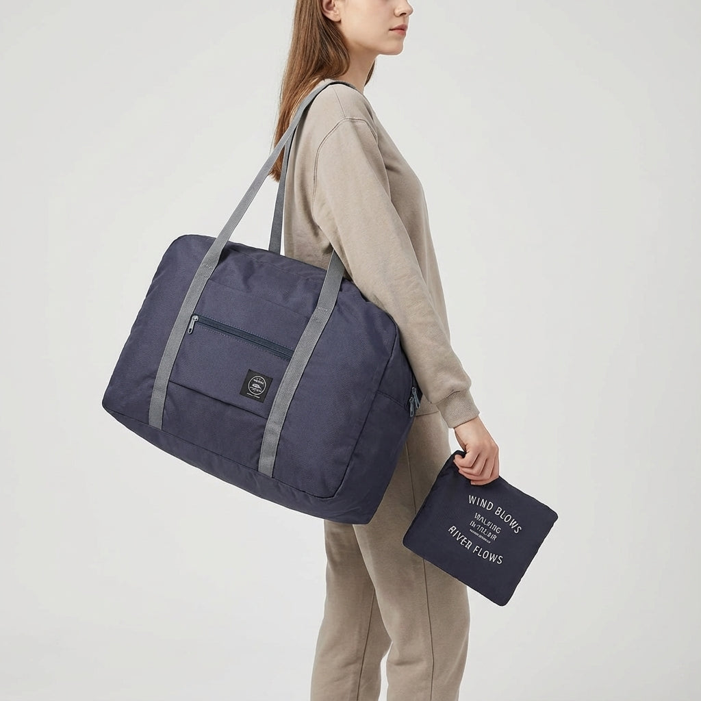 Person carrying a black lightweight foldable travel duffel bag. Perfect unisex carry-on for airport & weekend.