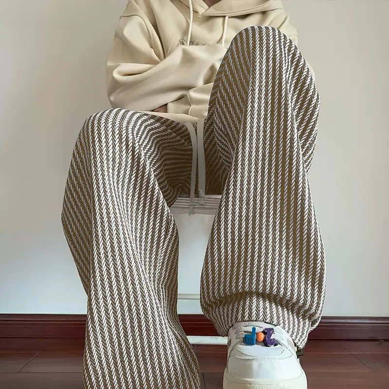 Black unisex herringbone sweatpants, relaxed wide leg with drawstring waist & practical side pockets.