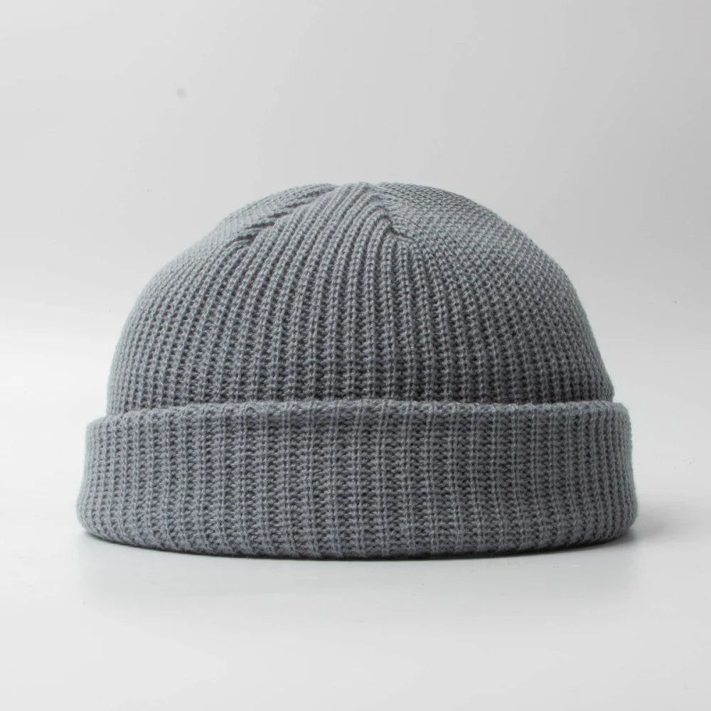 Classic knitted skull cap beanie hat, unisex design. Warm cotton blend headwear accessory for winter.
