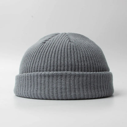 Classic knitted skull cap beanie hat, unisex design. Warm cotton blend headwear accessory for winter.