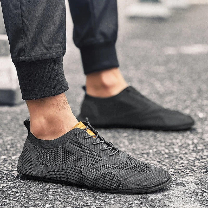 Close-up of sole texture on breathable unisex walking shoes; lightweight knit slip-on design.