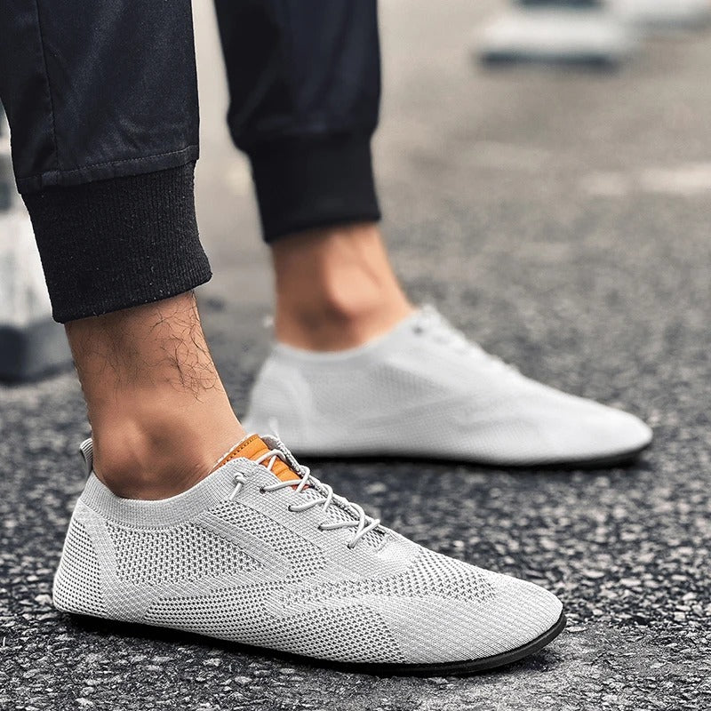 White unisex lightweight mesh knit slip-on sneakers, stylish and breathable for everyday comfort.