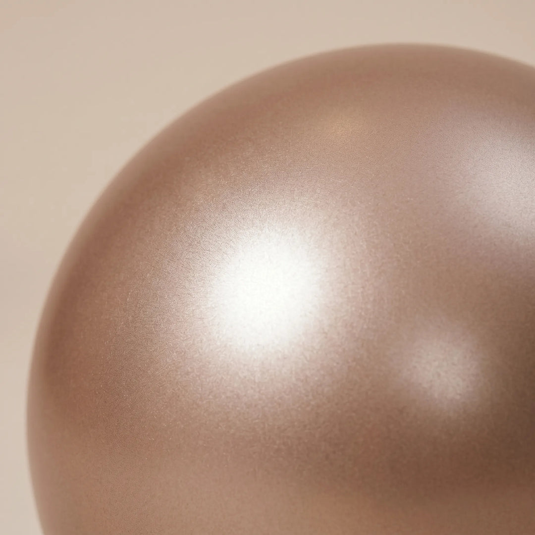 Mini pilates ball in use, enhancing core stability and flexibility during home workouts for strength training.